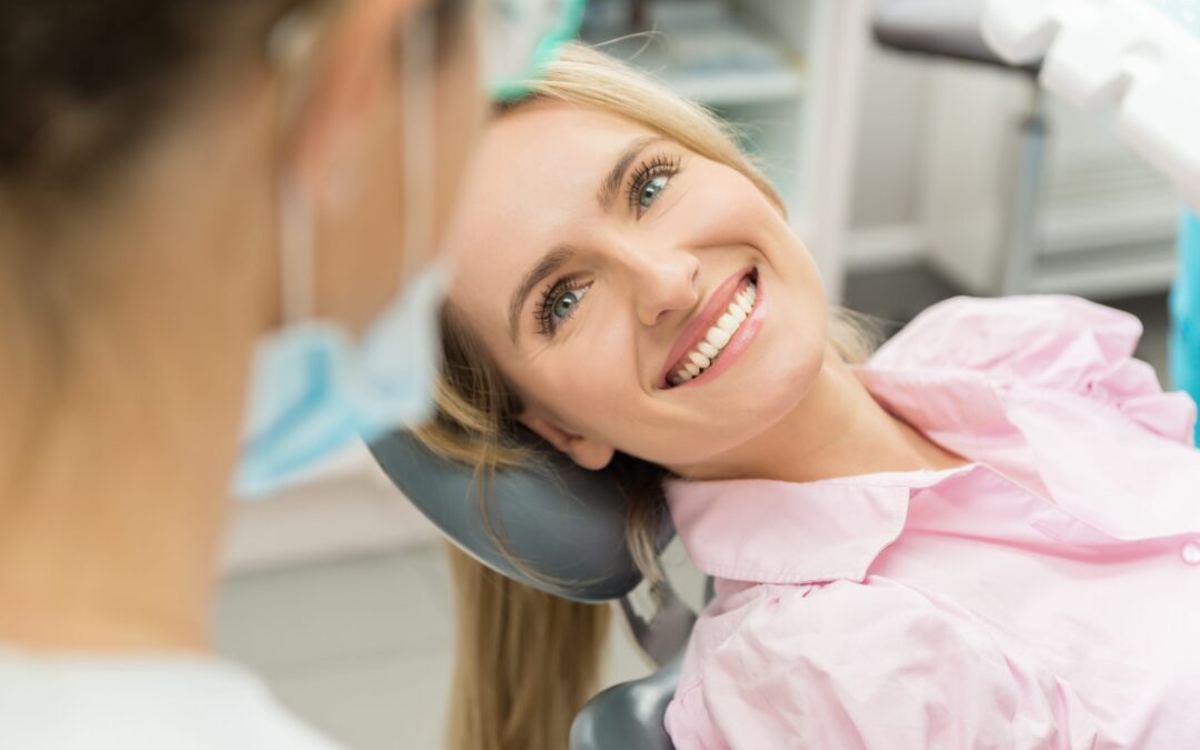 women smiling in dentist chair with dentist in the room